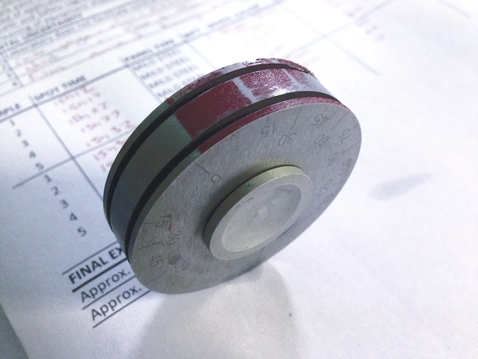 A wet-film thickness gauge resting on a completed Marindec quality-control record